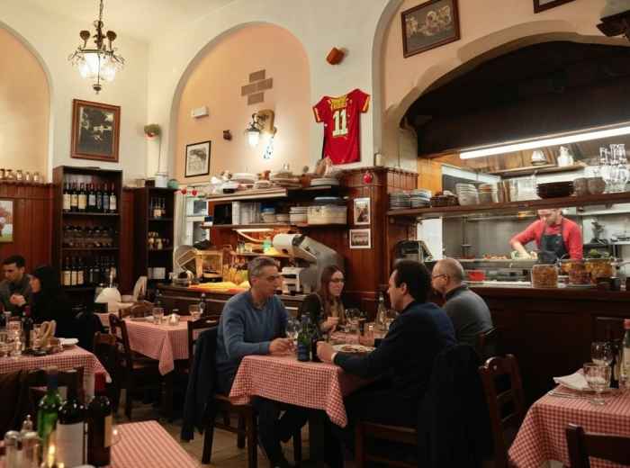 Cozy trattoria interior with wine bottles and checkered tablecloths