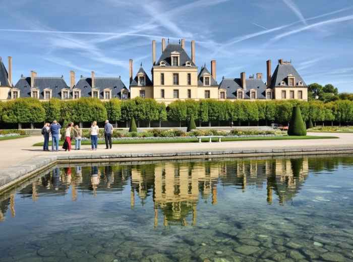 Forest path through ancient oaks at Fontainebleau with sandstone boulders