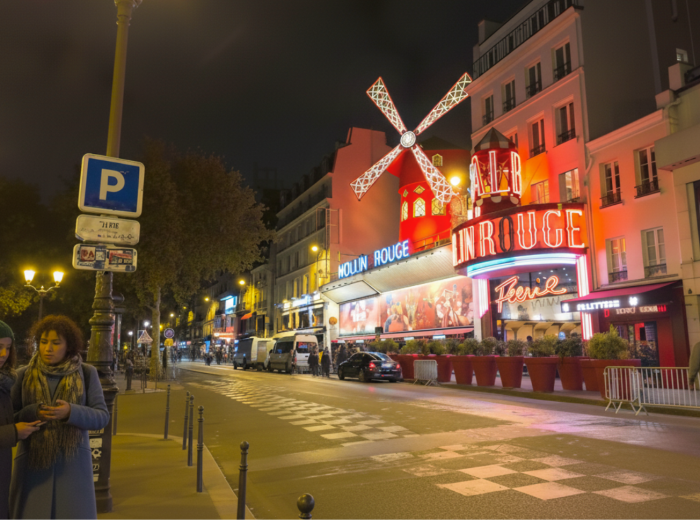 Moulin Rouge red windmill illuminated against the sky in Pigalle