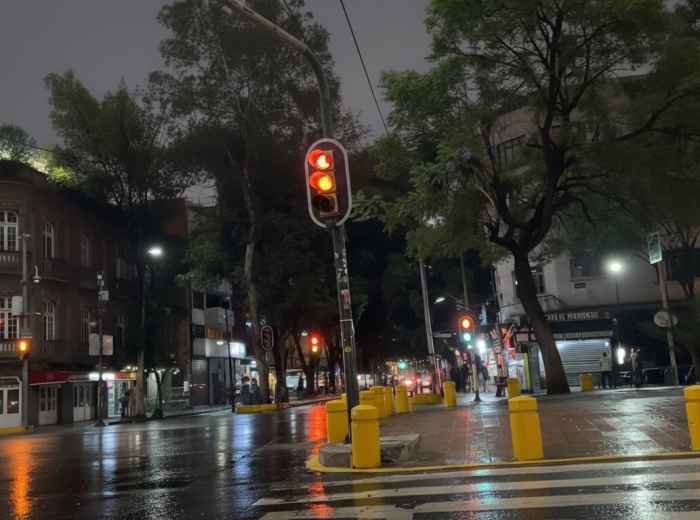 Lights reflecting on wet pavement in Roma Norte at night