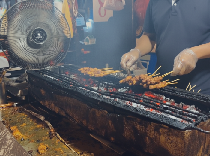 Night scene at Lau Pa Sat with satay vendors grilling on closed street