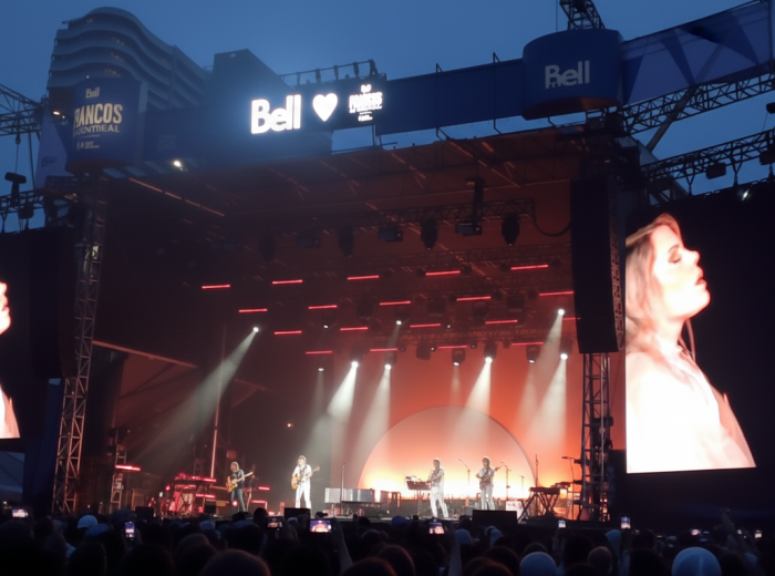 Festival les Francos stage at night with large crowd and colorful lights
