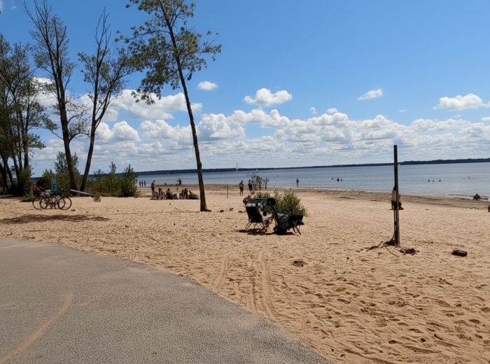 Sandy beach on Lac des Deux Montagnes with people swimming in distance