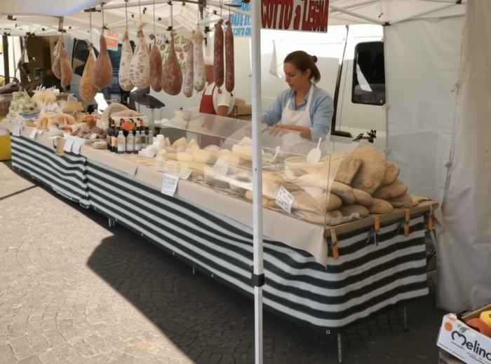 Market stalls in Greve's piazza with hanging salami