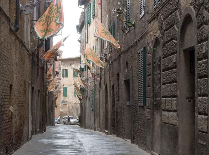 Colorful contrada flags on medieval buildings