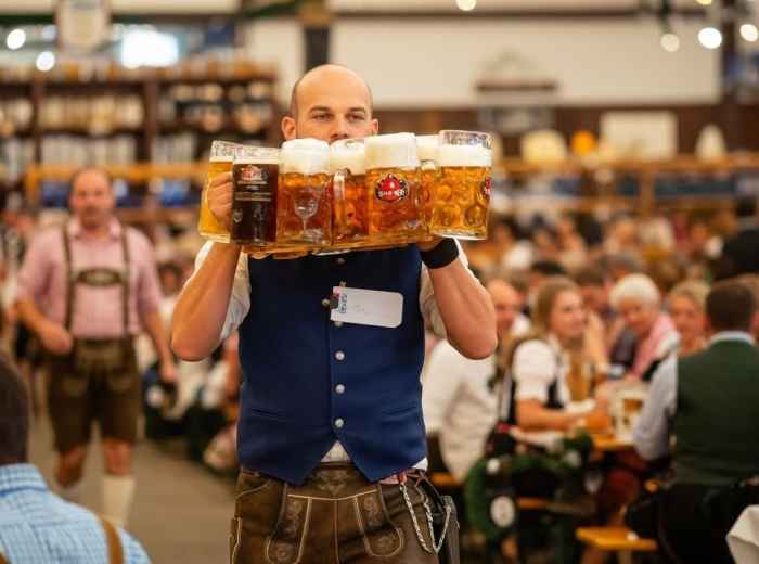 Dinner bill and coins on a wooden beer hall table in Munich