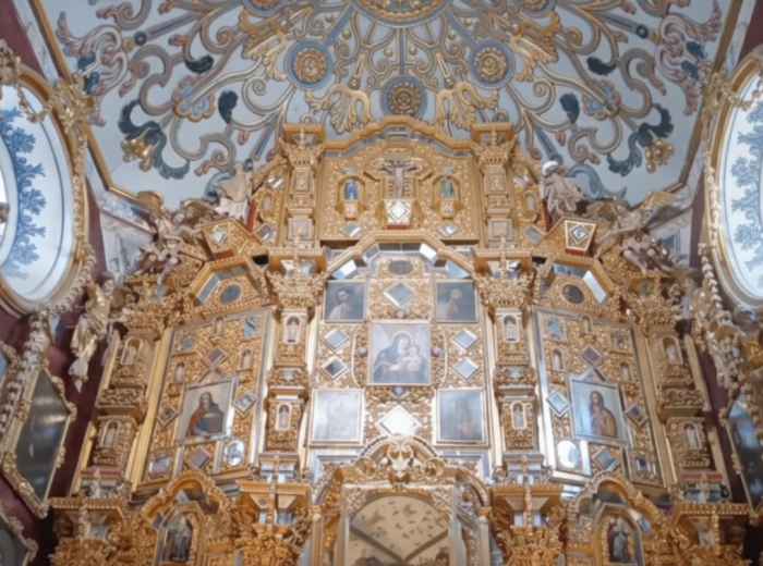 Ornate baroque church interior with gold altar and detailed ceiling