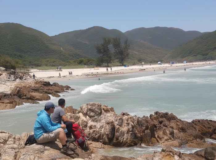 Turquoise water at Tai Long Wan beach with hikers resting