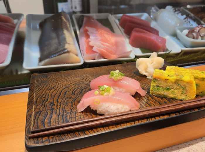 Fresh nigiri sushi served on a wooden board at Tsukiji Fish Market in Tokyo