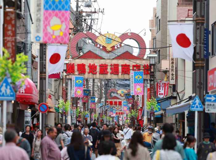 Jizo Dori Shopping Street in Sugamo, Tokyo, with pedestrians under the market gate
