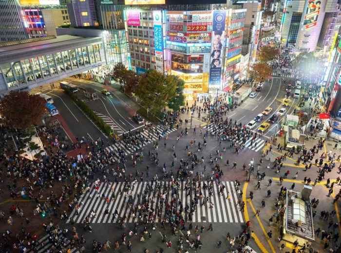 Crowds crossing Shibuya Crossing at night, Tokyo’s busiest intersection