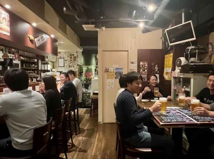 Cozy counter bar with locals enjoying beer and sake in Shibuya after work