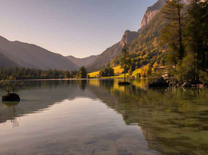 Hintersee shoreline with pine reflections at golden hour