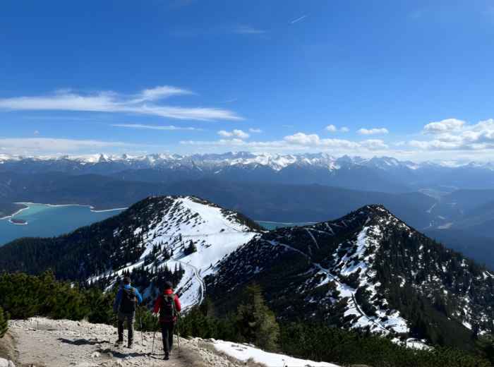 Hiker on Herzogstand ridge with lakes visible below
