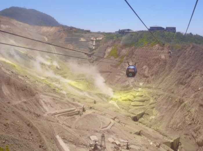 Hakone ropeway cabin traveling over a steaming volcanic valley