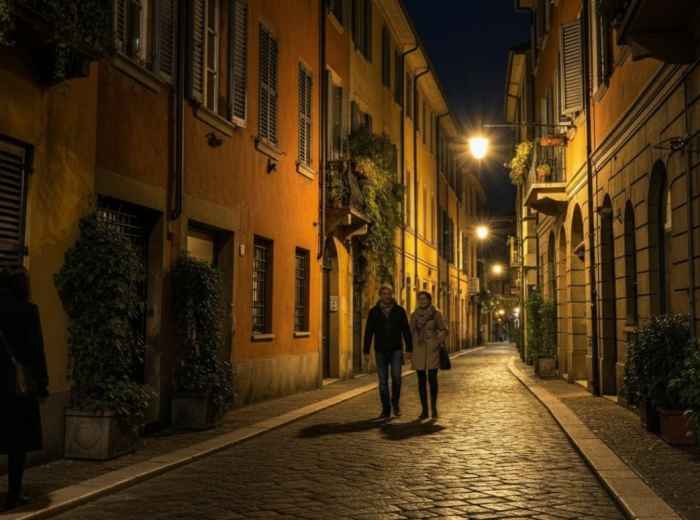 Quiet Brera side street after dark with warm lights and evening walkers