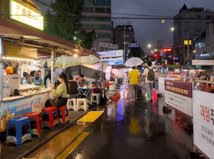 Pojangmacha tents on a rainy Seoul street late at night