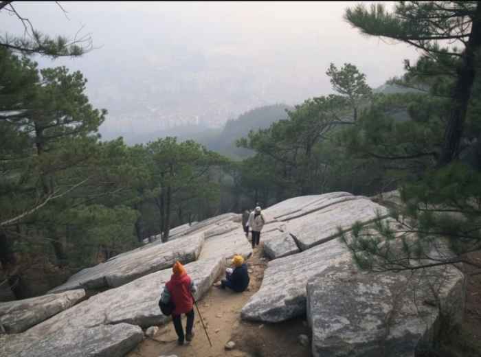 Granite slabs on Bukhansan with Seoul below in haze