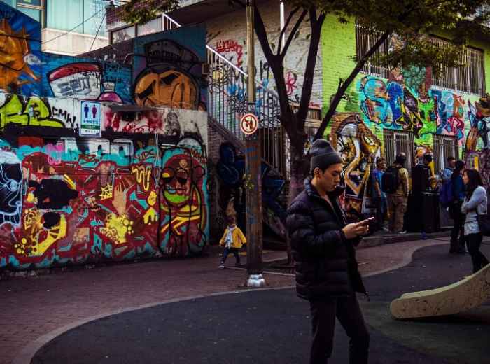 Graffiti-covered street in Hongdae with young crowd