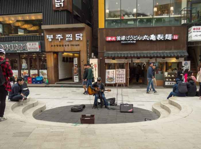 Street musician drawing a small crowd in Hongdae