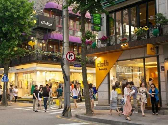 Locals walking along a lively Seoul neighborhood street