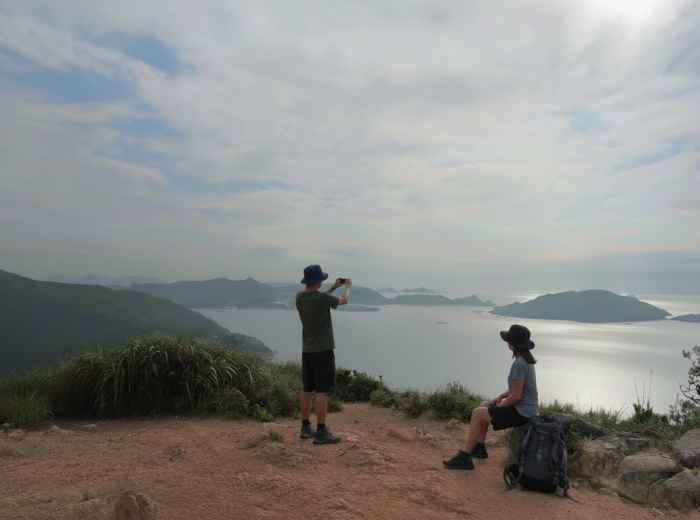 Two hikers pausing at a viewpoint on Dragon’s Back