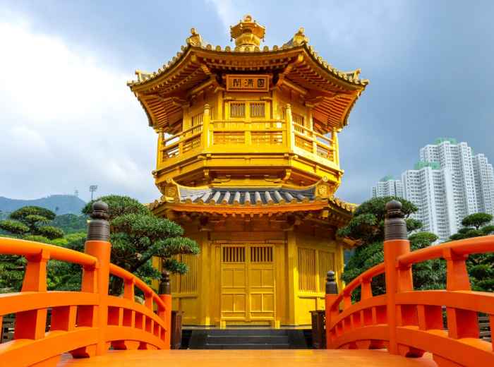 Golden pavilion at Nan Lian Garden with red bridge and city skyline