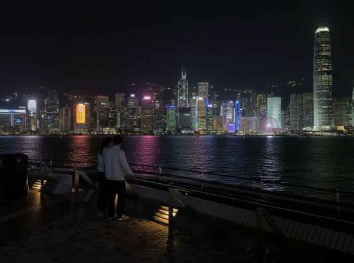 Victoria Harbor skyline at night viewed from waterfront promenade