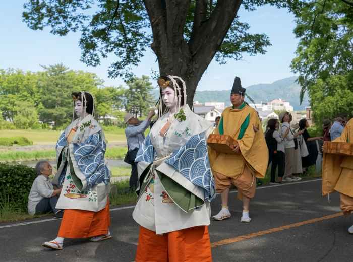 Aoi Matsuri procession walking beside the Kamo River in Kyoto