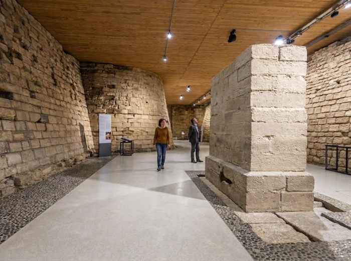People walking among the medieval fortress foundations beneath the Louvre