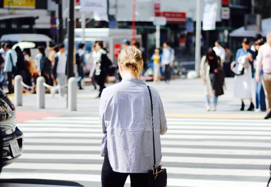woman standing at a crosswalk alone