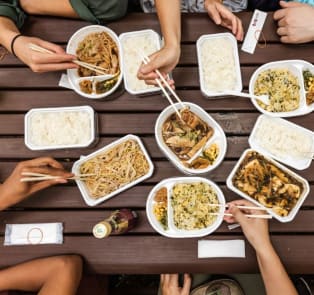 Various Japanese dishes with people sitting around the