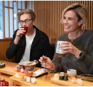 Travelers enjoying sushi in Tokyo, Japan