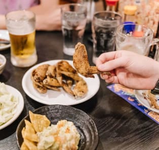 Various Japanese dishes and a hand holding a piece of a