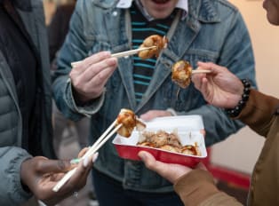 People eating street food with chopsticks