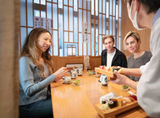 Travelers about to enjoy sushi with a local host in Tok