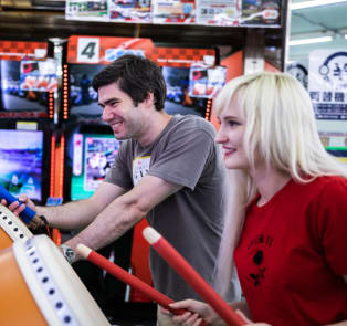 Travelers playing arcade games in Tokyo