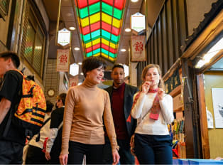Travelers exploring Nishiki Market on a walking tour in