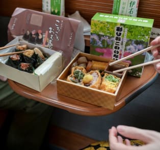 Sushi bento box and two people are enjoying their own b