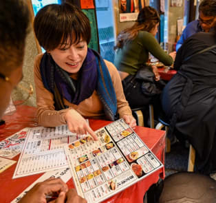 Local host showing guests a menu on a Kyoto food tour