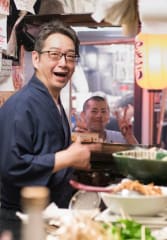kobe beef tours Tourists enjoying a meal with a local guide at a busy restaurant in Japan