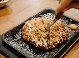 Okonomiyaki is a crispy and gooey Japanese specialty