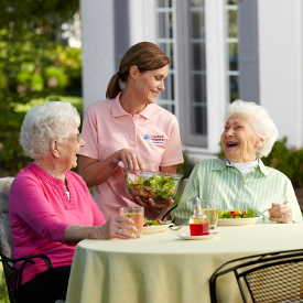 caregiver-serving-salad-to-seniors