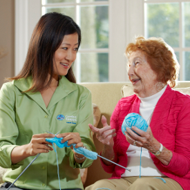 caregiver helps elder with knitting