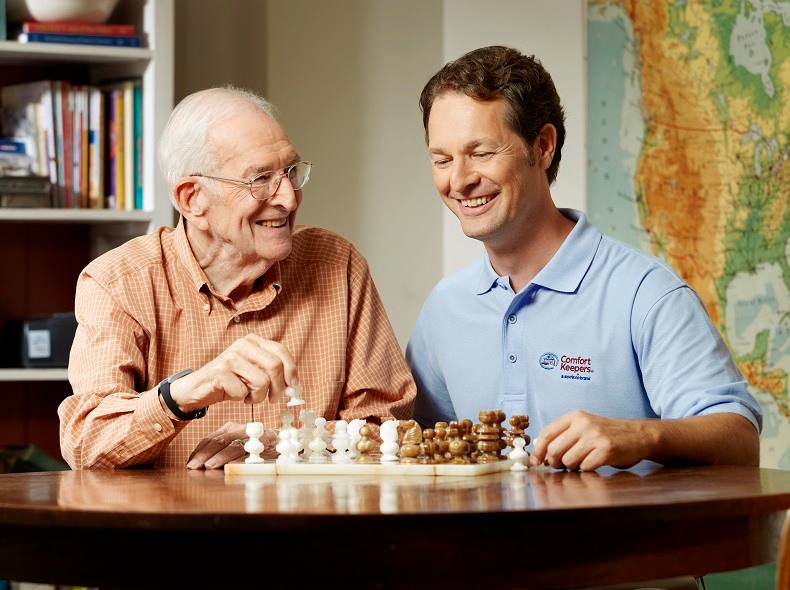 A 24 hour home care provider playing chess with a senior man in Snyder, TX