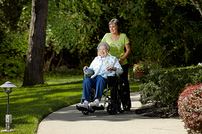 caregiver-pushing-senior-in-wheelchair