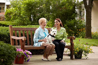 senior-with-dog-next-to-caregiver-outside