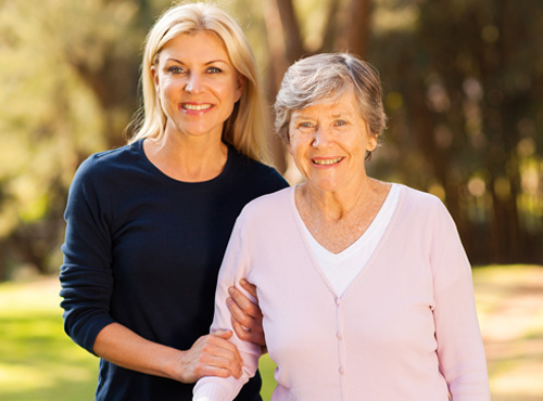 young woman and elderly lady standing next to each other and smiling for a picture 