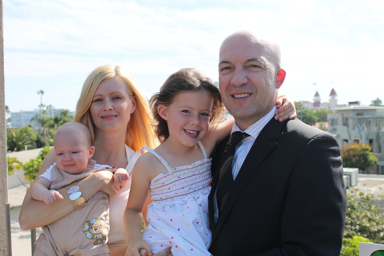 George, his wife and children on the balcony of the California Plaza with the Hotel del Coronado in the background.