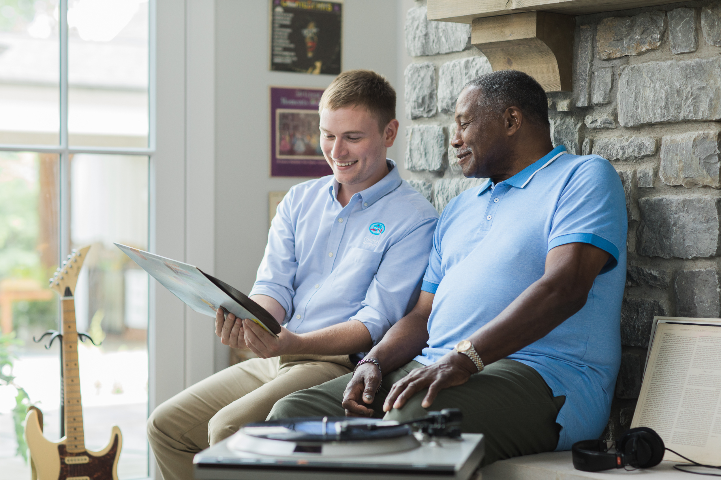 Comfort Keepers Caregiver and senior looking at a record and listening to music